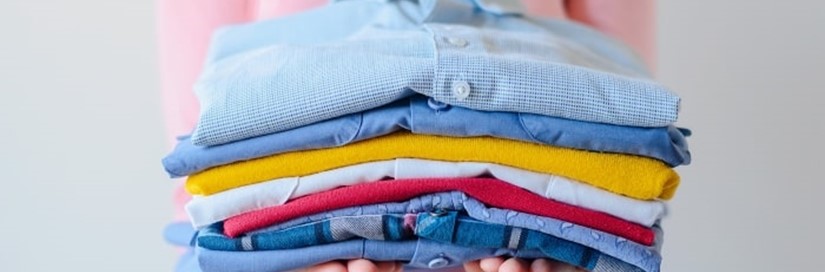 Girl Holding Pile Of Washed And Ironed Clothes Min